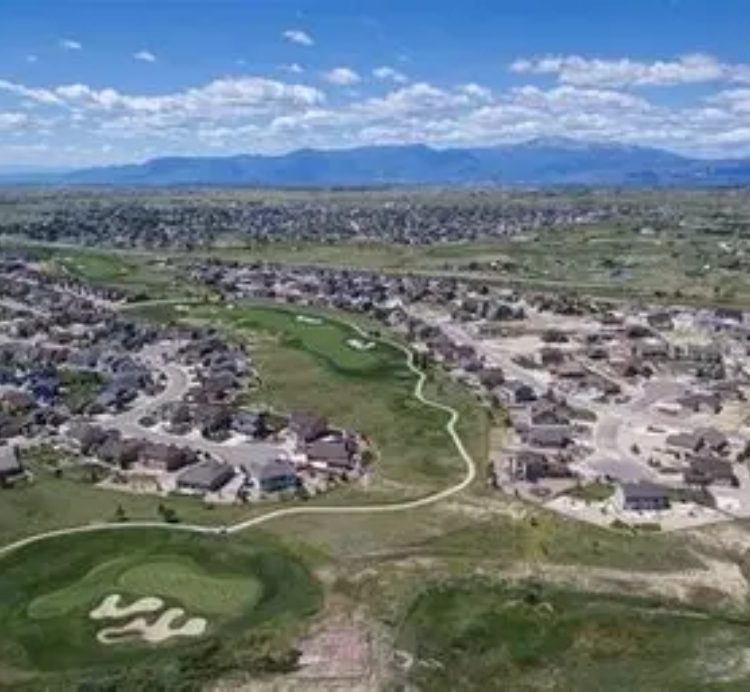 A suburban neighborhood with a golf course and mountain views.