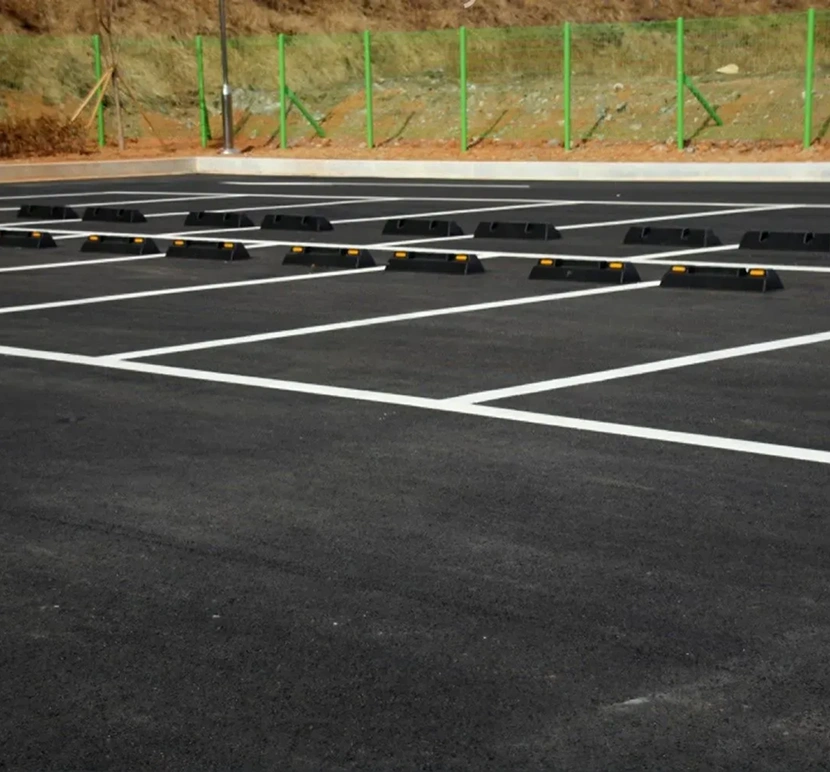 Empty parking lot with green fence