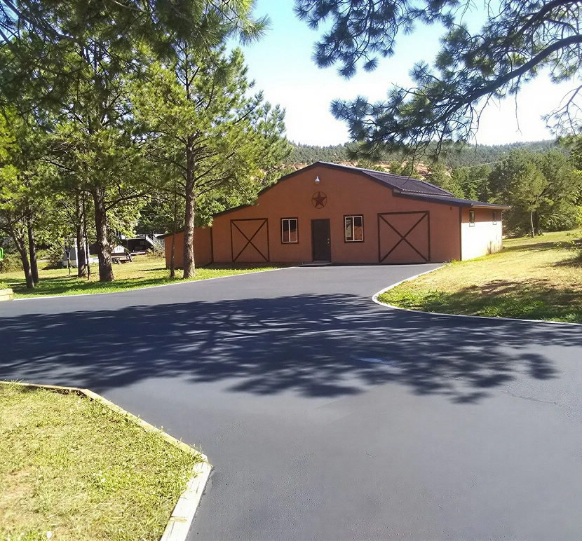 Barn with paved driveway and trees